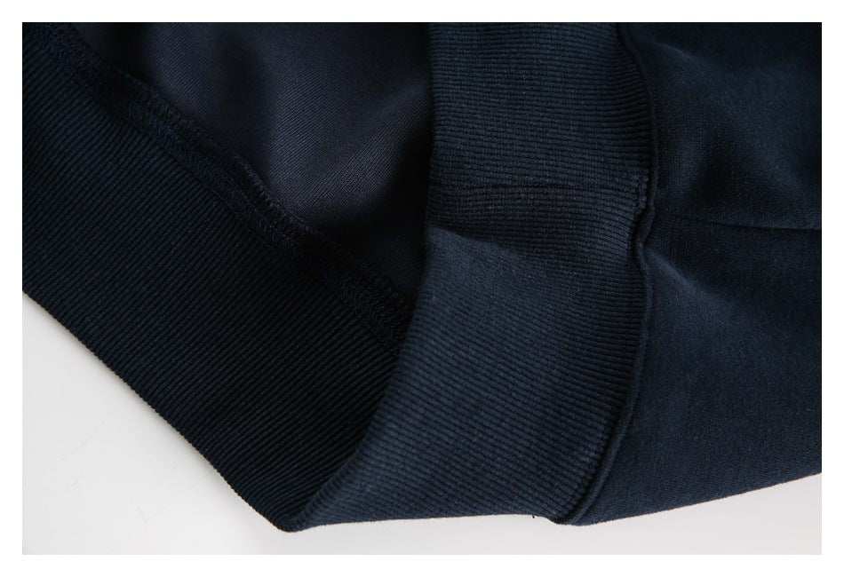 Close-up of a dark navy sweatshirt's ribbed hem and stitched seam.