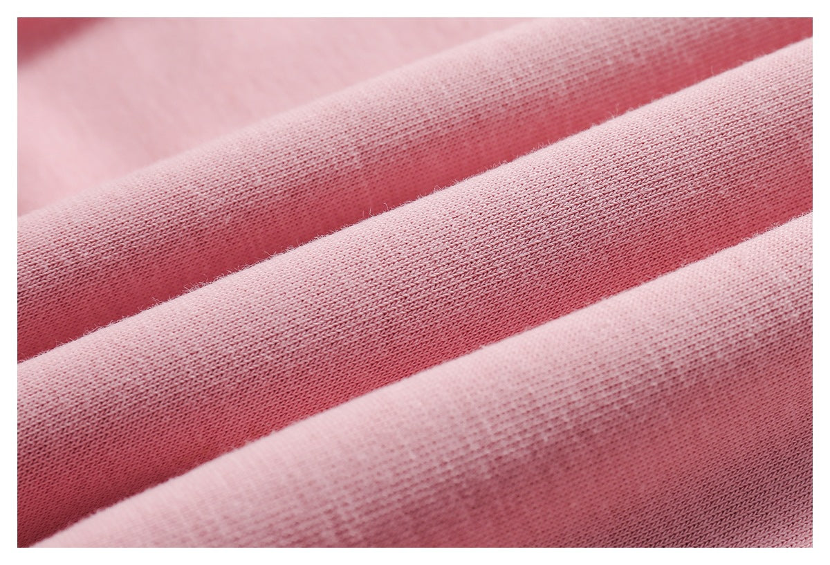 Close-up of pink knit fabric folded to show its texture and stitching.