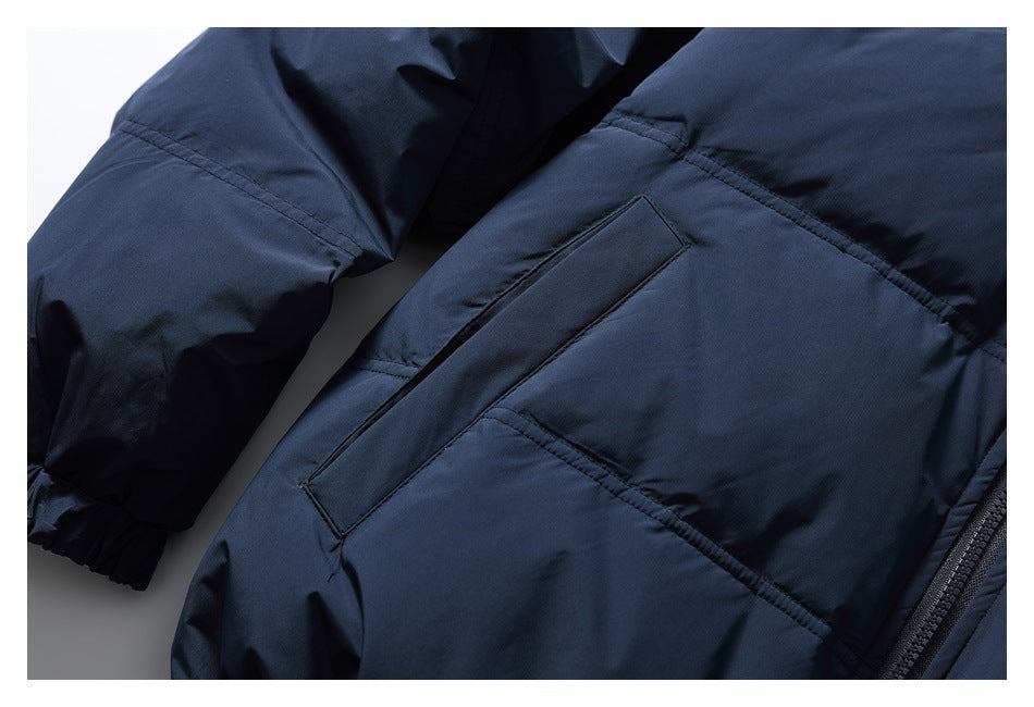 Angled close-up of a welt pocket, panel seams, and sleeve on the dark navy jacket.
