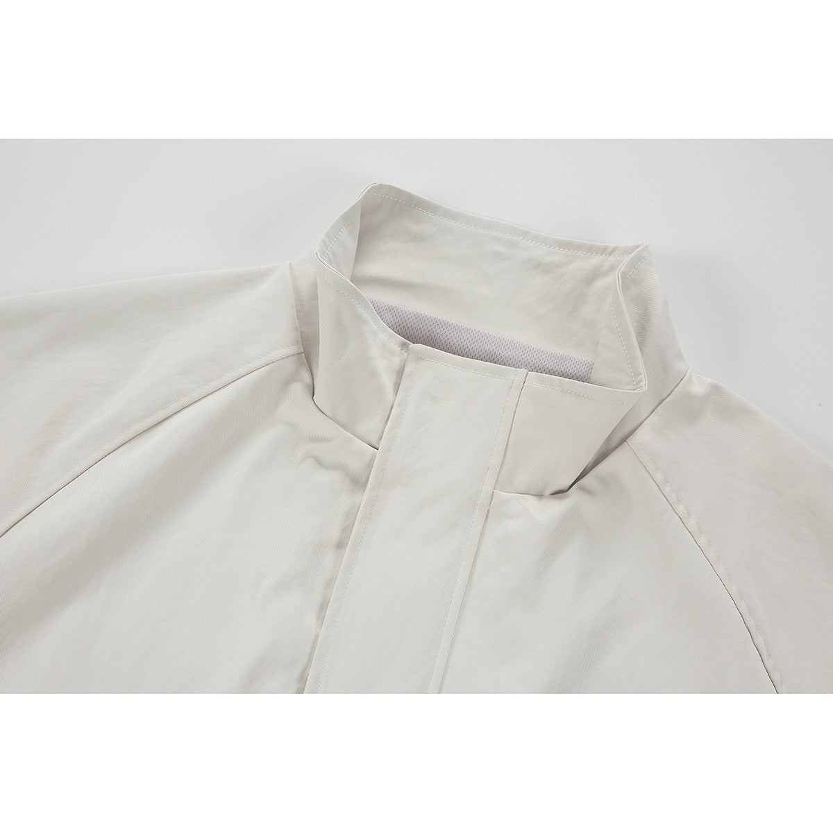 Close-up of an ivory jacket's tall stand collar and concealed front placket.
