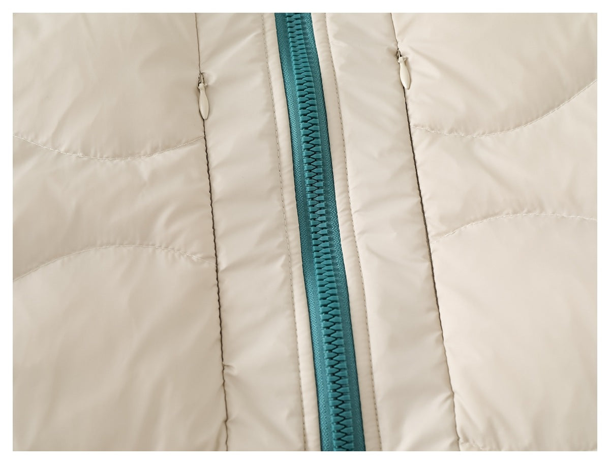 Close-up of the teal front zipper and two vertical pockets on an ivory quilted jacket.