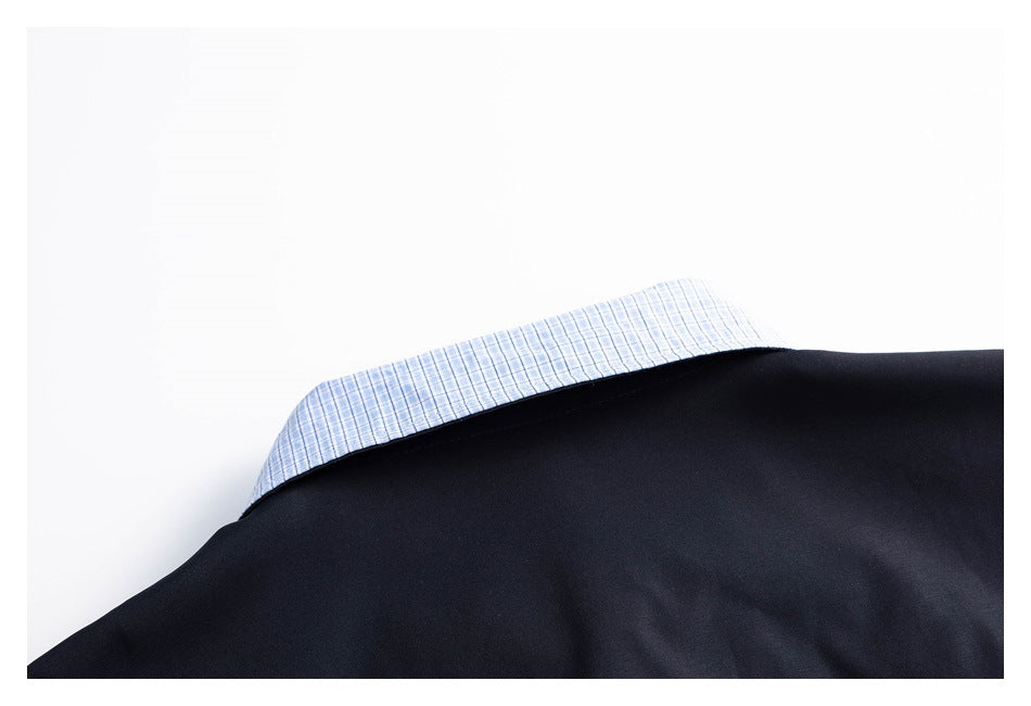 Close-up of a dark navy jacket edge with blue-and-white checked fabric visible beneath it.