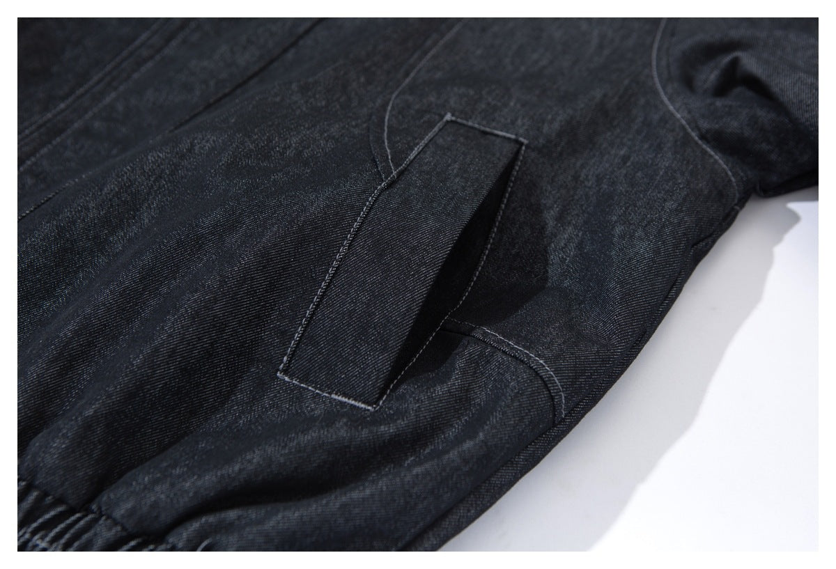Close-up of a rectangular pocket and curved seams on dark indigo fabric.