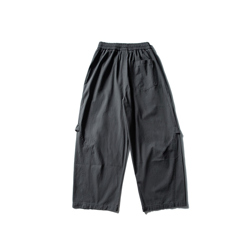 Back view of charcoal wide-leg cargo pants with an elastic waistband, rear patch pocket, and side cargo pockets.