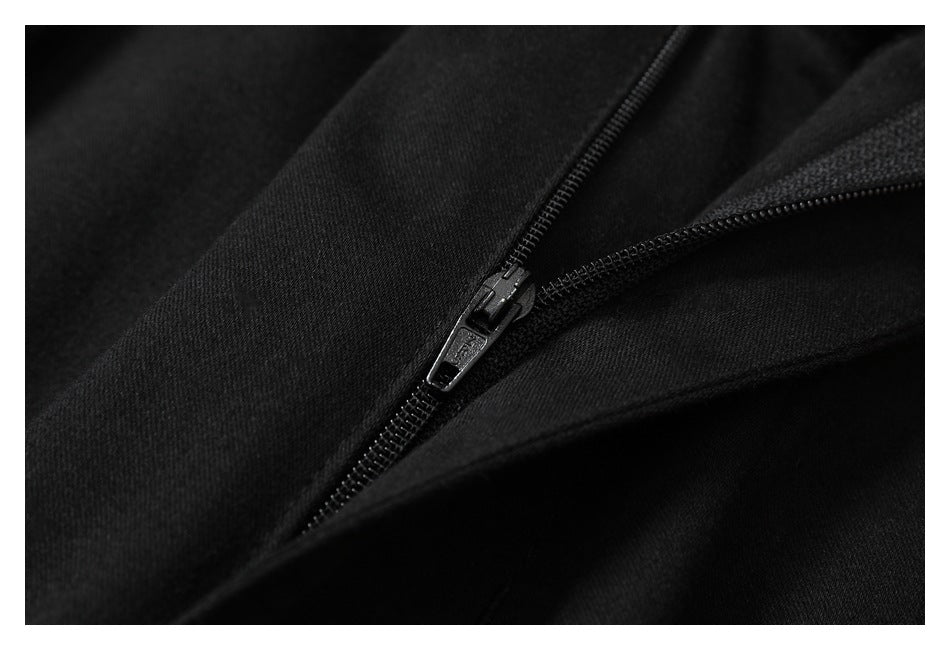 Close-up of a black trouser zipper and surrounding fabric.