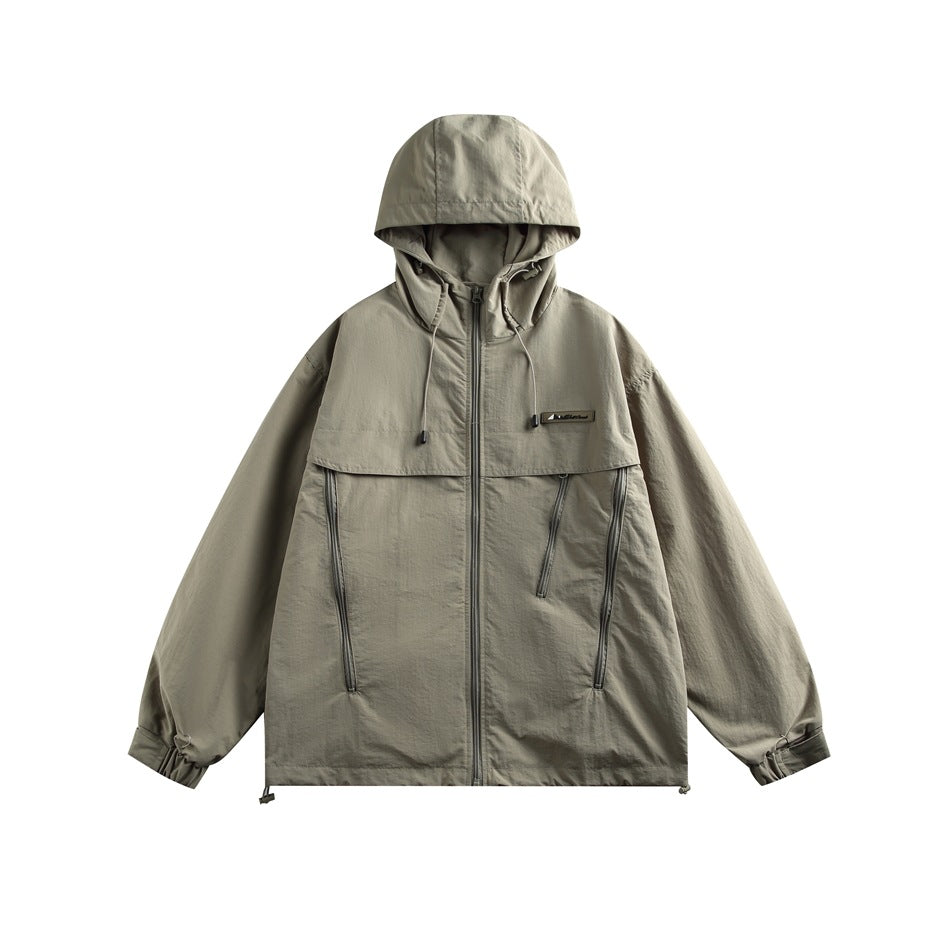 Front view of a gray-green hooded jacket with a central zipper, chest flap, angled zip pockets, and adjustable cuffs.