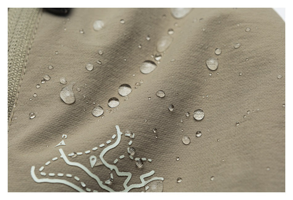 Close-up of taupe fabric with water droplets and a white map-like graphic near a seam.