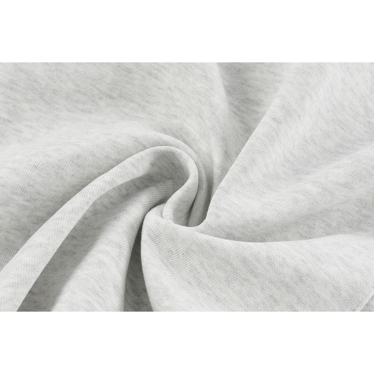 Close-up of light gray knit fabric gathered into soft folds.