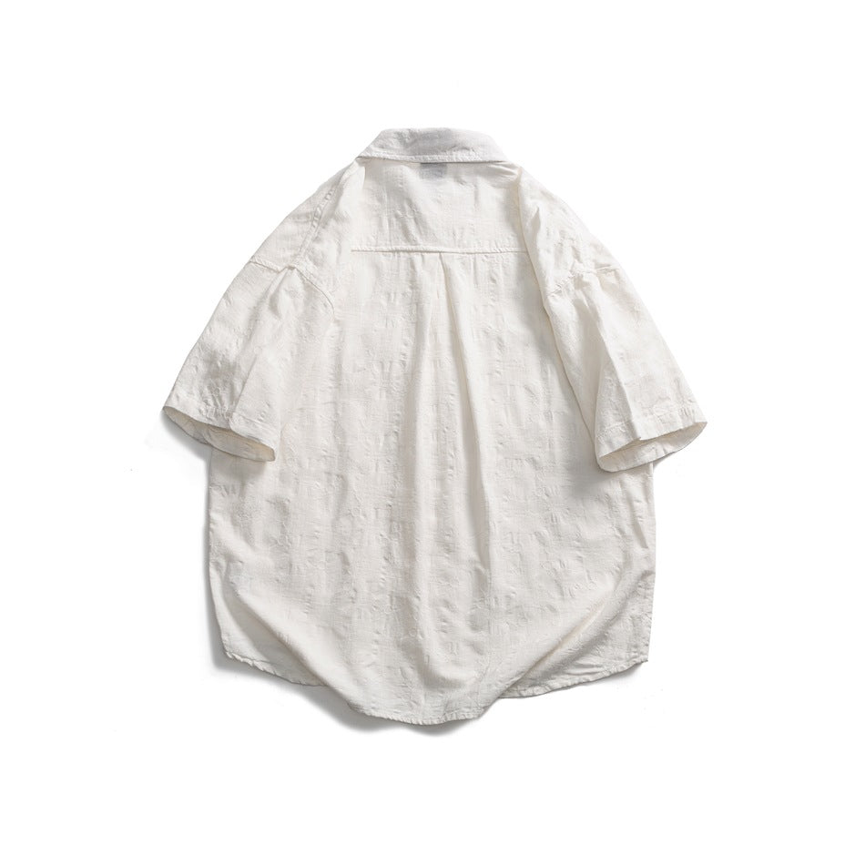 Back view of a white short-sleeve button-up shirt with a subtle textured pattern and center pleat.