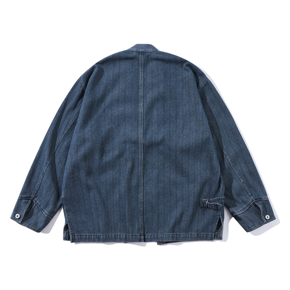 Back view of a blue denim jacket with a center seam, snap cuffs, and a small side waist tie.