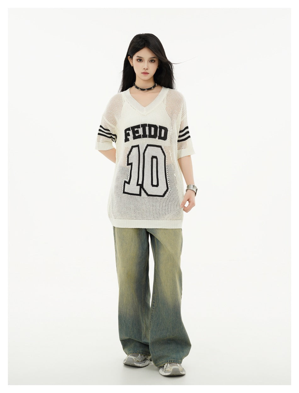 Front view of a model in an ivory mesh-knit V-neck jersey with black sleeve stripes and FEIDD 10 lettering, and wide-leg