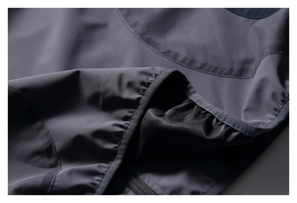 Close-up of a charcoal gray jacket's fabric and finished edge, with dark mesh-like lining visible.