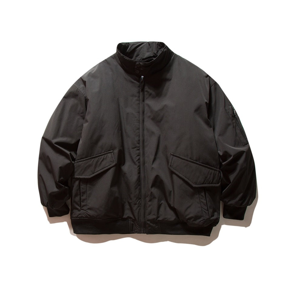 Black stand-collar zip jacket with large flap pockets and ribbed cuffs and hem, flat lay front view