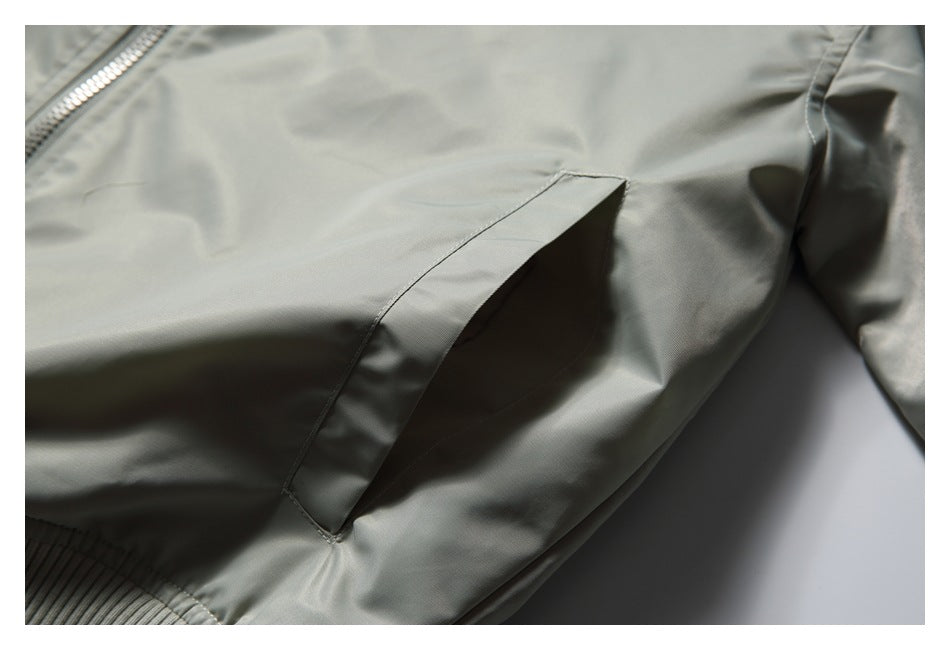 Close-up of a slanted welt pocket on the pale gray-green jacket.