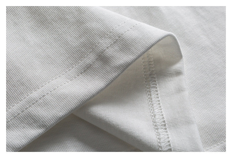 Close-up of a white garment hem with double stitching and an overlocked inner seam.