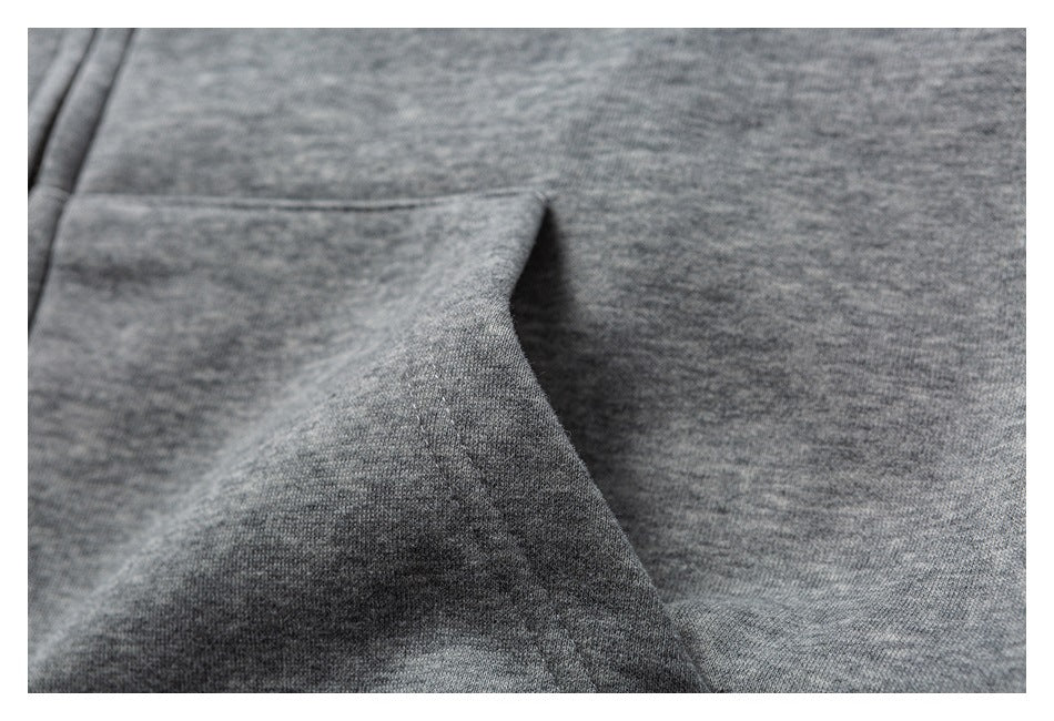 Close-up of a gray sweatshirt's fabric and pocket opening.