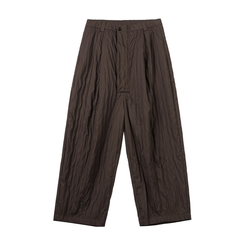 Brown wide-leg pleated pants with crinkled texture, button waistband and covered fly, front flat lay