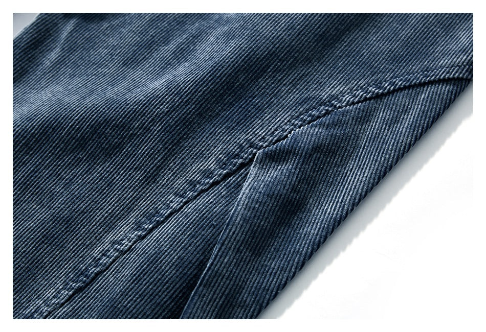 Close-up of blue-gray ribbed corduroy fabric and a stitched seam.