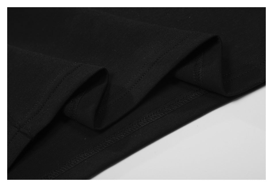 Close-up of a black garment’s folded hem and interior overlock stitching.