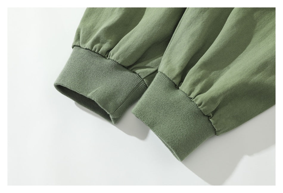 Close-up of sage-green sleeves with gathered fabric and wide ribbed cuffs.