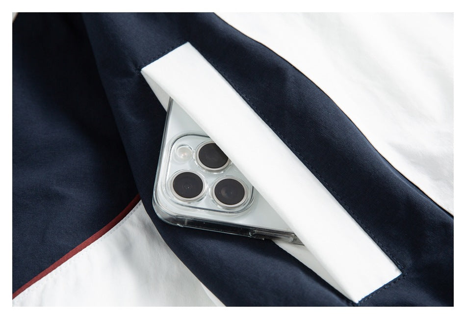 Close-up of a white and navy garment pocket with a phone tucked inside.