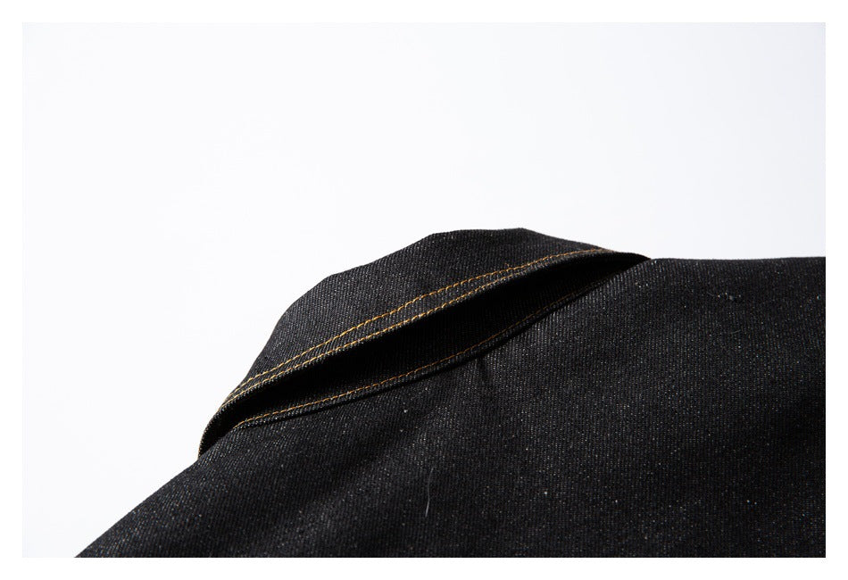 Close-up of a black denim jacket collar with golden contrast stitching.