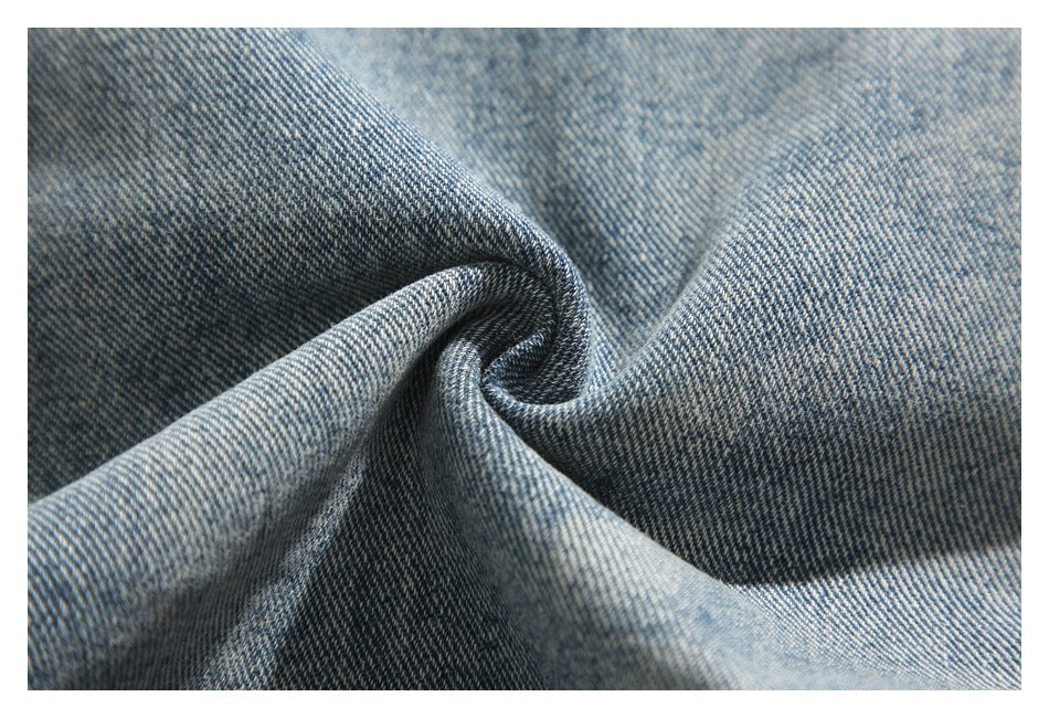 Close-up of light blue denim gathered into folds, showing its diagonal twill texture.