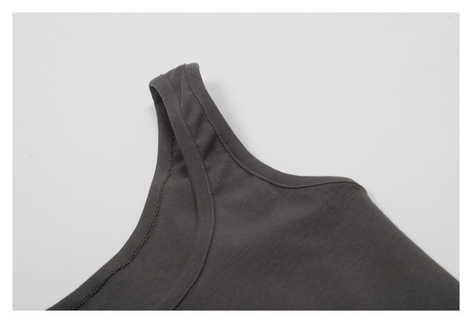 Close-up of the charcoal tank's shoulder strap and neckline binding with visible stitching.