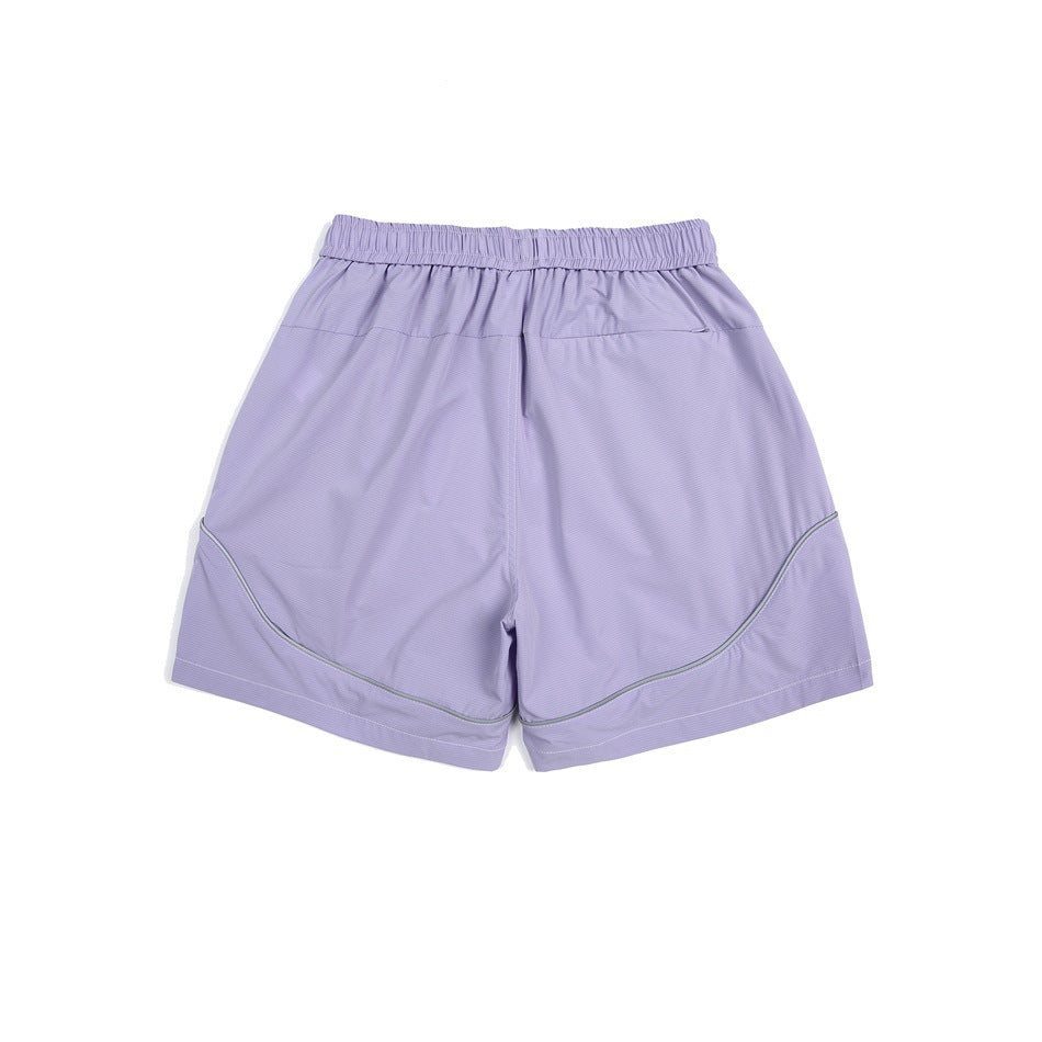 Lavender shorts shown flat with an elastic waistband, side pockets, and curved gray piping.