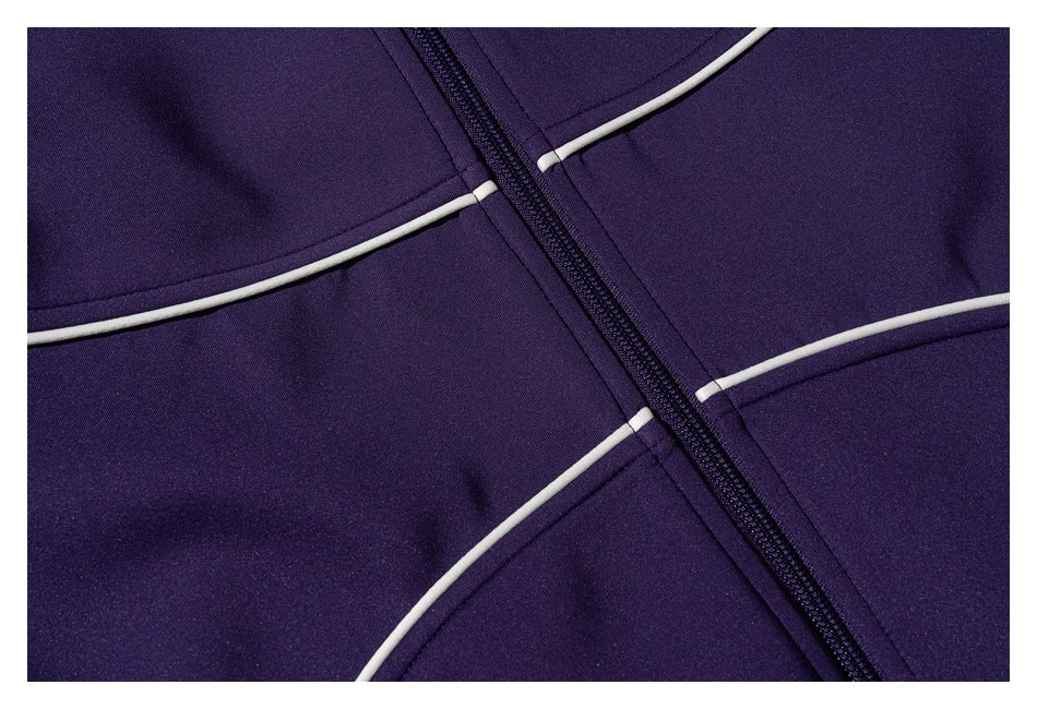 Close-up of a purple jacket's front zipper and intersecting white piping.