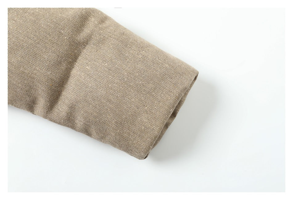 Close-up of a beige woven jacket sleeve with a wide folded cuff.