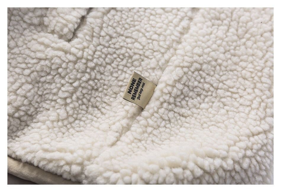 Close-up of cream looped fleece with a small sewn label bearing black lettering.