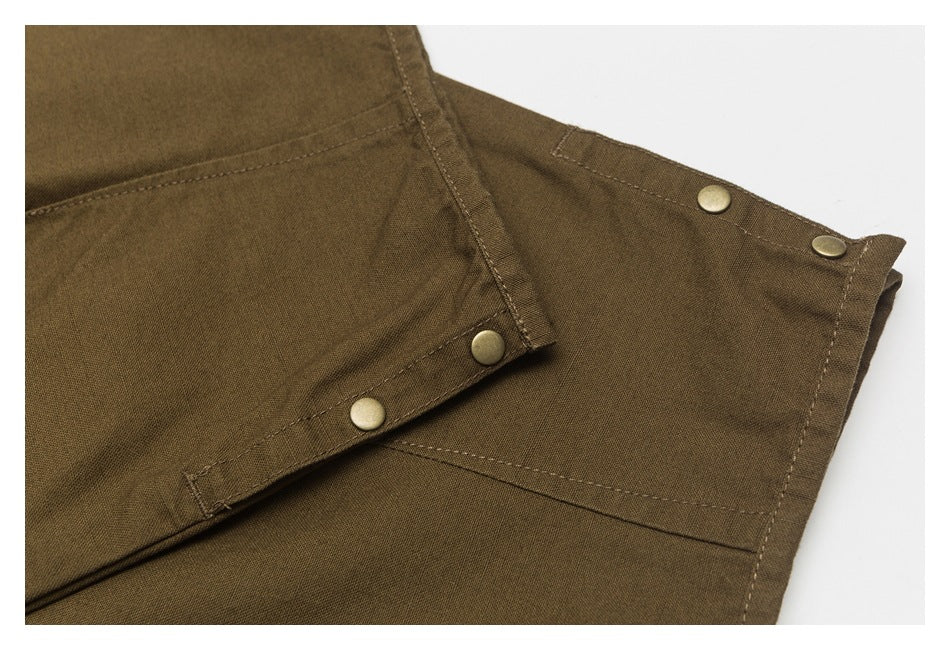 Close-up of dark olive-brown garment panels with stitched seams and brass-tone snap buttons.