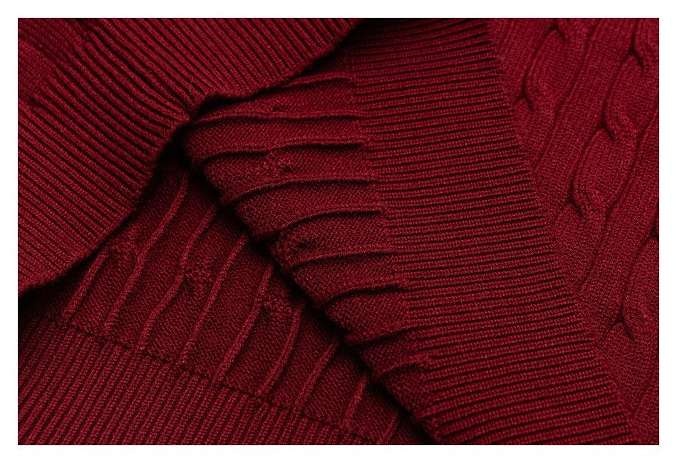 Close-up of a deep burgundy knit sweater showing ribbed and textured stitching.