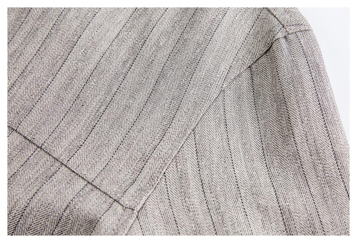 Close-up of the jacket's pinstriped fabric and stitched shoulder seam.