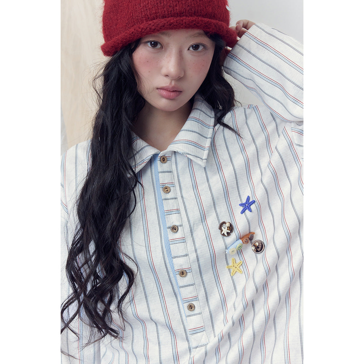Close-up of a striped white shirt with a pointed collar, button placket, and colorful starfish and novelty-button