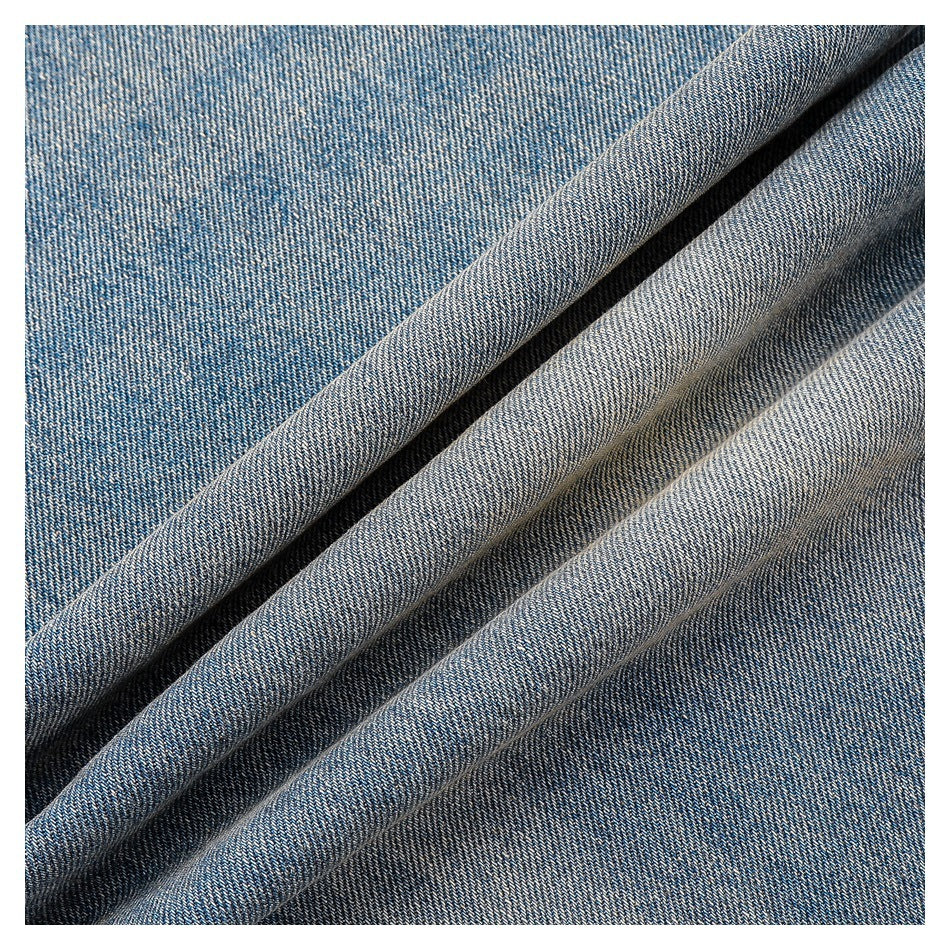 Close-up of blue denim fabric arranged in diagonal folds.
