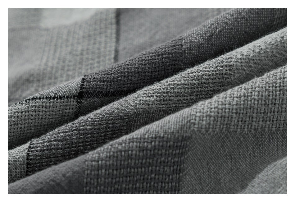 Macro view of the gray shirt fabric, showing raised woven texture and layered folds.
