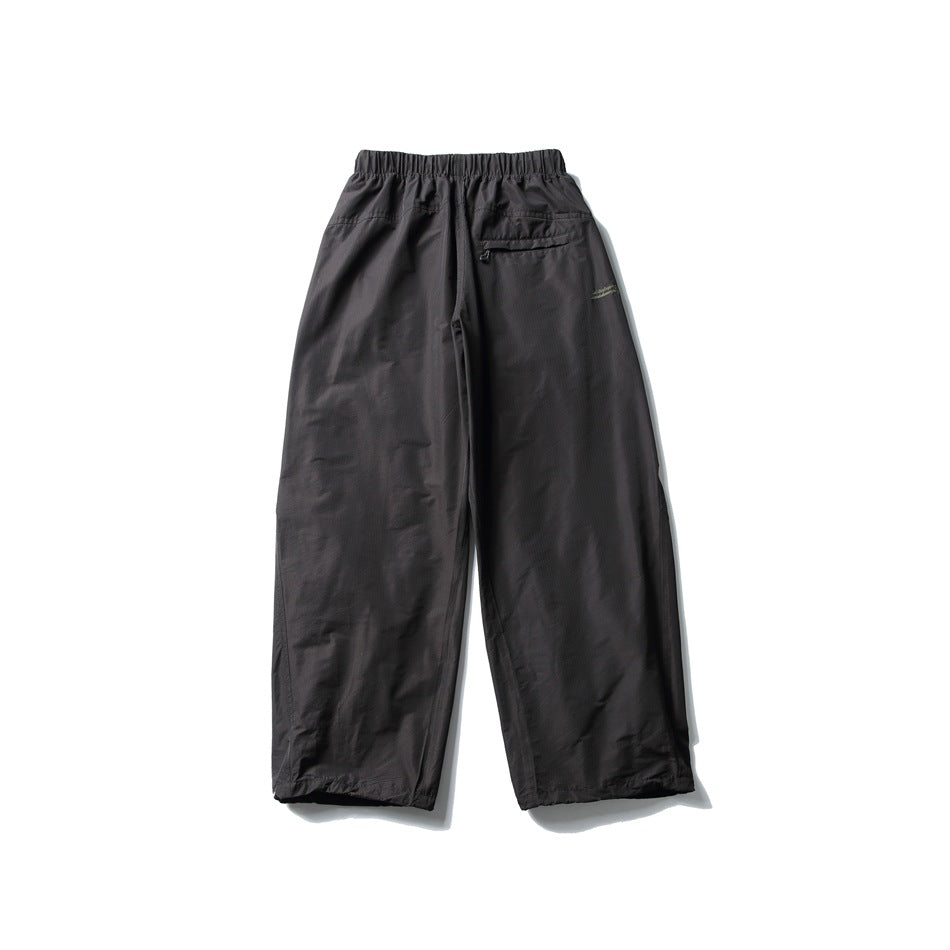 Charcoal wide-leg pants laid flat, with an elastic waist and a small zip pocket at the back.
