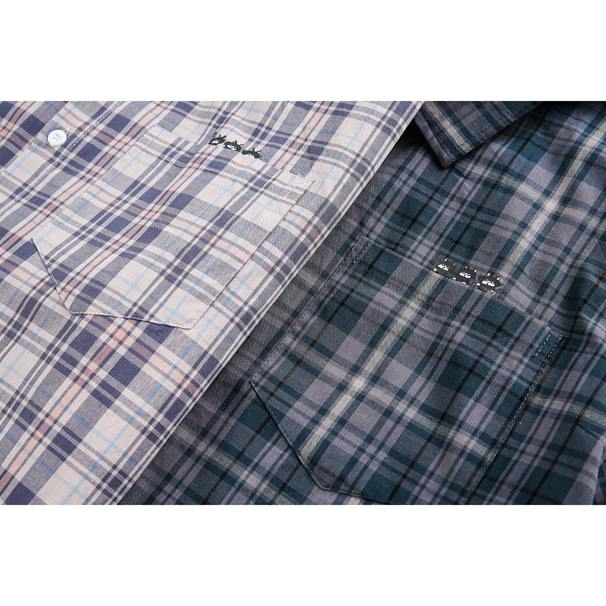 Close-up of pale and dark plaid shirt pockets with small cat graphics above them.