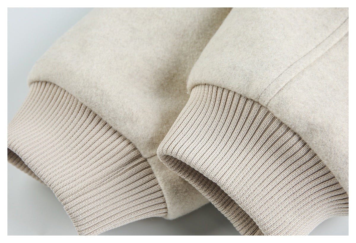 Close-up of pale beige jacket sleeves with wide ribbed knit cuffs.