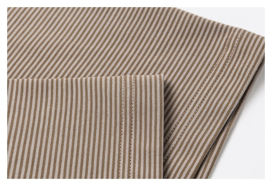 Close-up of folded beige and brown striped fabric showing stitched seams and a finished edge.