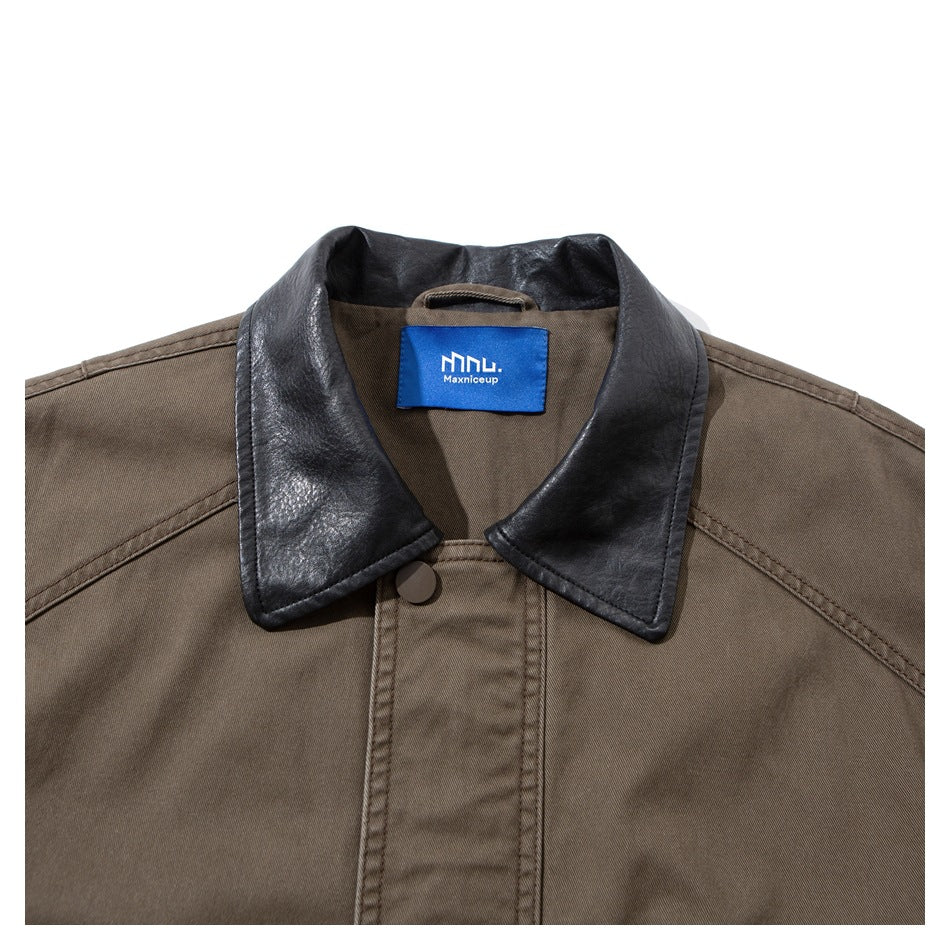 Close-up of a taupe jacket’s black collar, stitched shoulders, front placket, button, and blue neck label.