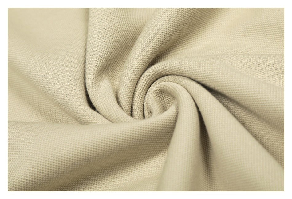 Close-up of beige fabric gathered to show its small textured knit pattern.