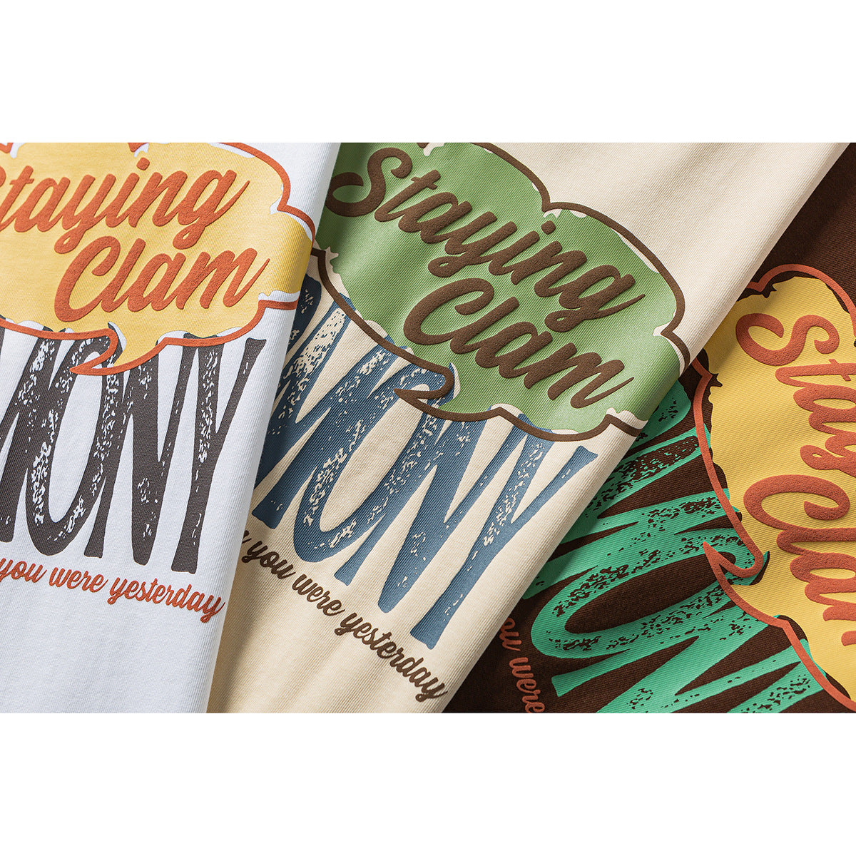 Close-up of colorful English graphic prints on white, pale yellow, and brown T-shirts.