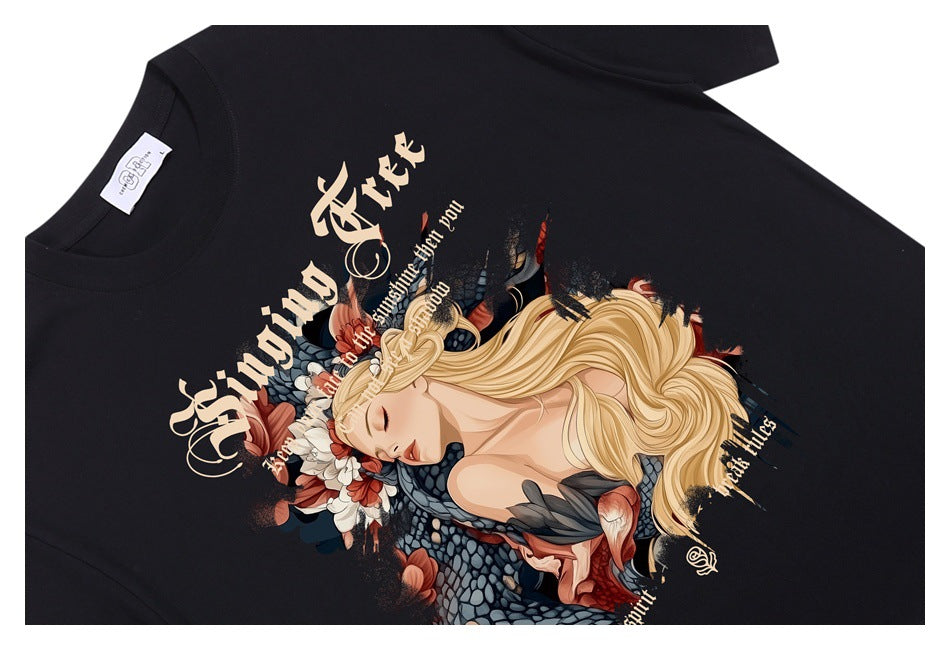 Black T-shirt laid flat, showing a large ornate illustration of a blonde woman with flowers and decorative lettering.