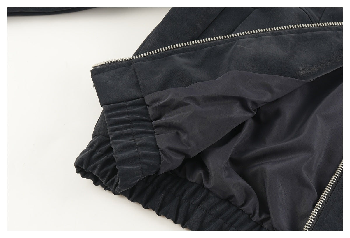 Close-up of the dark jacket opened to show its smooth lining, zipper and gathered elastic hem.
