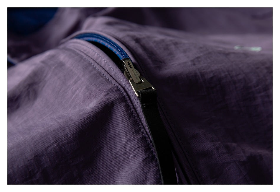 Close-up of a dark zipper with blue tape on a purple garment.