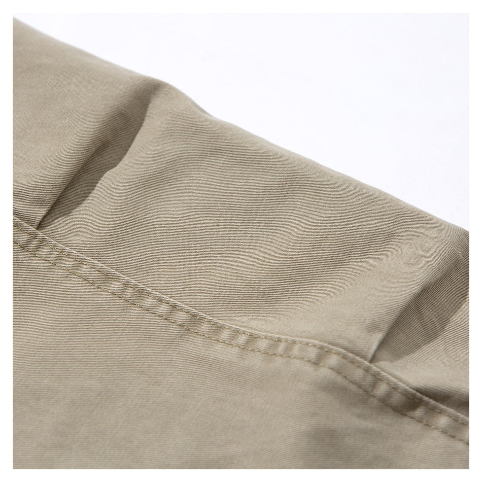 Close-up of beige fabric with a diagonal double-stitched seam.