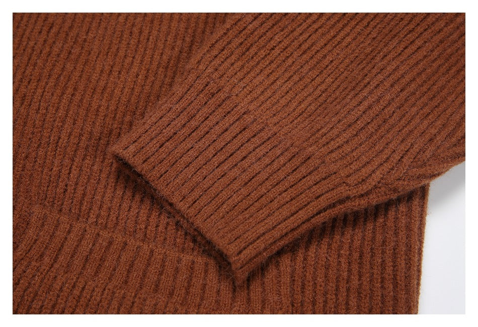 Close-up of a rust-brown ribbed knit sweater sleeve overlapping the body.